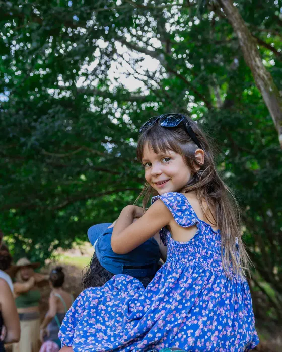 A girl looks back over her shoulder, smiling, on a forest trail at Amora, Dominicalito, Costa Rica.